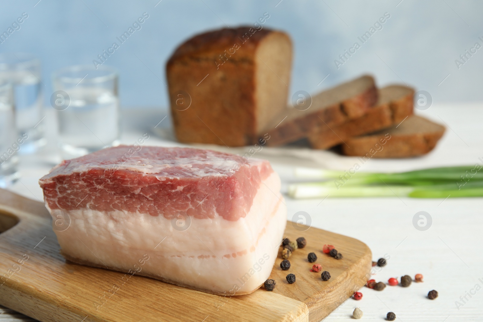 Photo of Composition with pork fatback on white table. Space for text