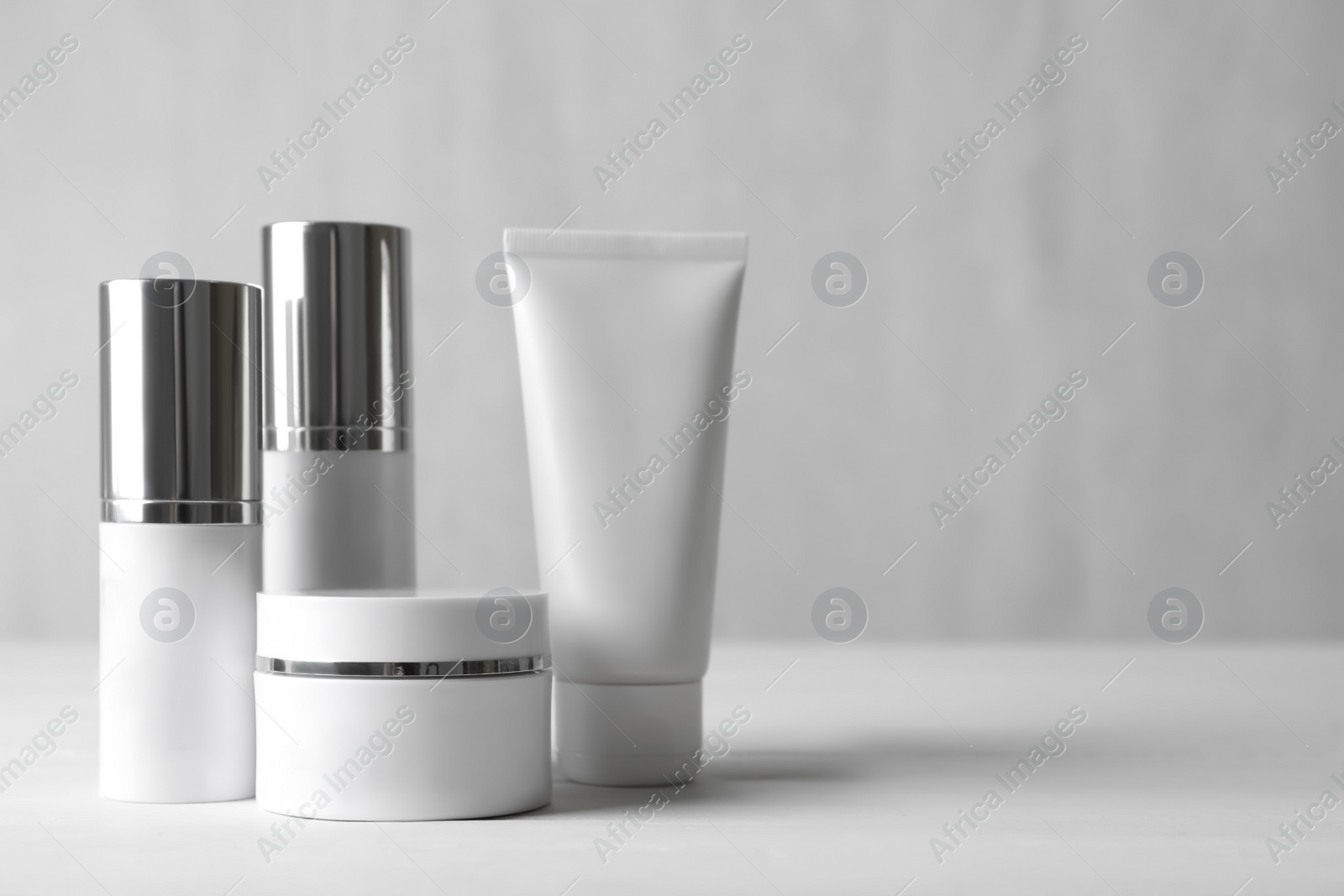 Photo of Set of luxury cosmetic products on white table. Space for text