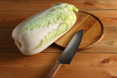 Photo of Fresh Chinese cabbage and knife on wooden table