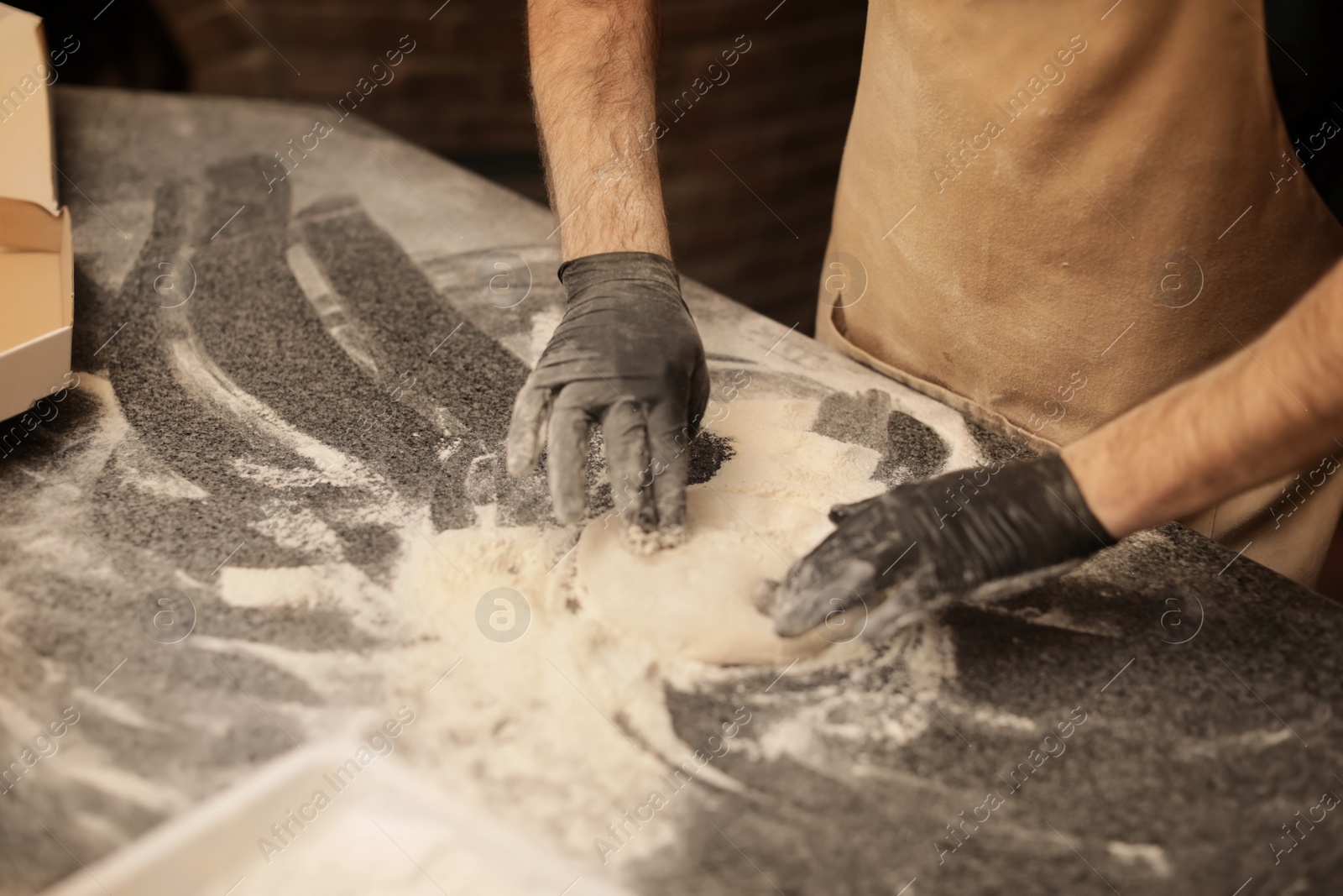 Photo of Man making pizza at table, closeup view