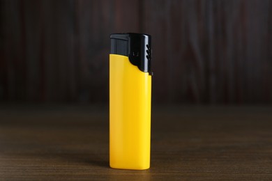 Photo of Stylish small pocket lighter on wooden table