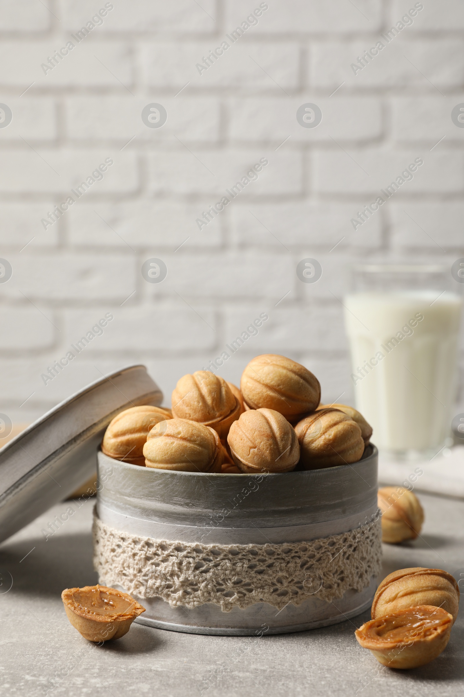 Photo of Delicious nut shaped cookies with boiled condensed milk on light grey table