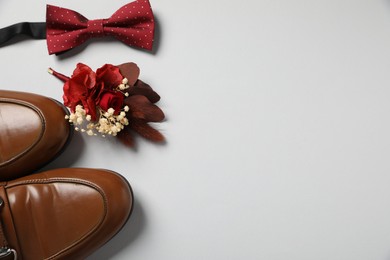 Photo of Wedding stuff. Stylish boutonniere, shoes and bow tie on gray background, flat lay. Space for text
