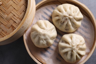 Photo of Delicious bao buns (baozi) on grey table, top view