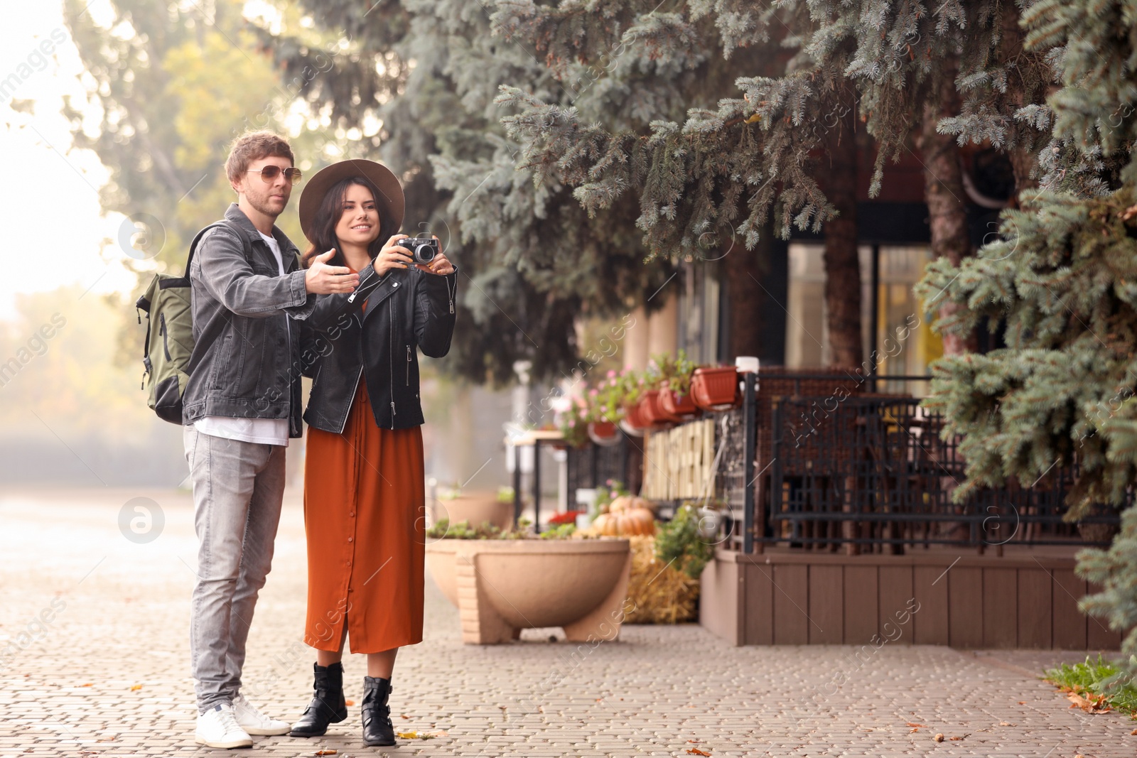 Photo of Couple of travelers with camera on city street