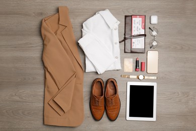 Photo of Flat lay composition with clothes, shoes and accessories on wooden background. Packing for business trip