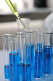 Photo of Laboratory analysis. Dripping liquid into test tubes indoors, closeup