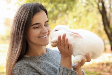 Photo of Woman holding cute white rabbit in park
