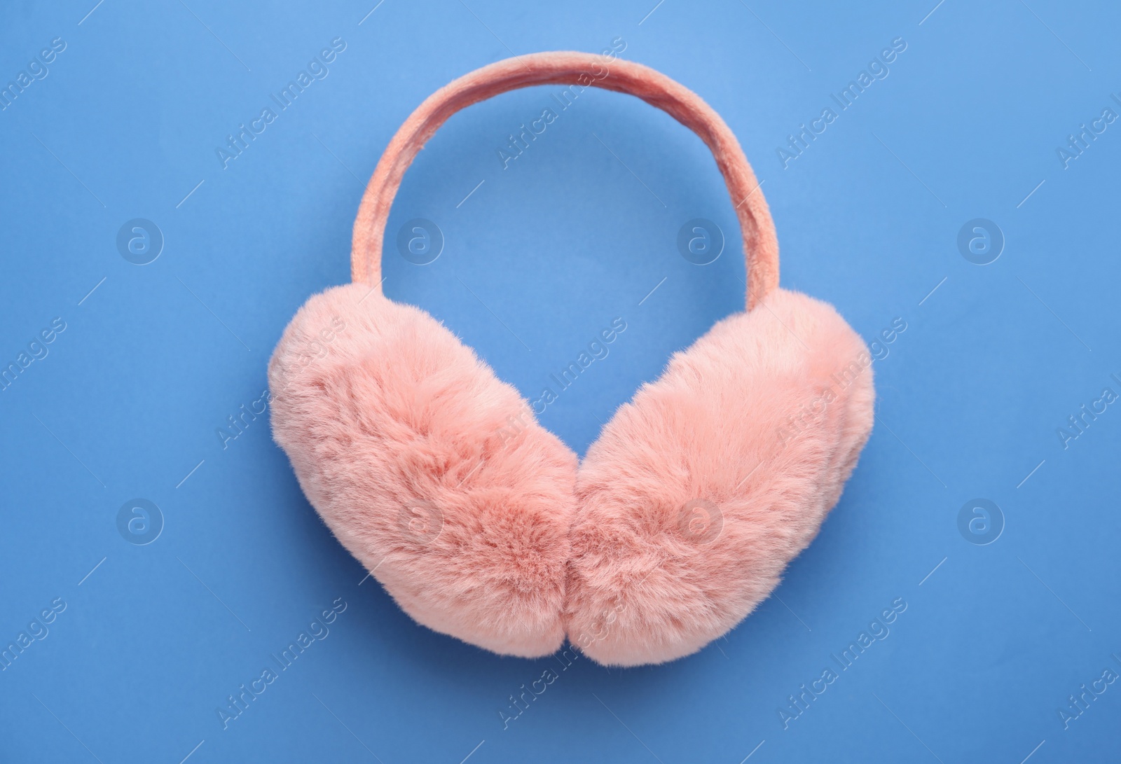 Photo of Stylish winter earmuffs on blue background, top view