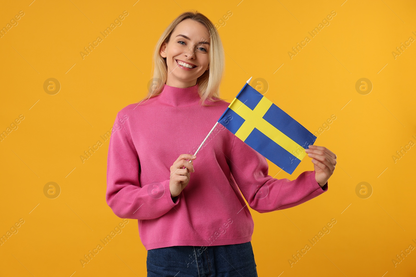 Photo of Happy woman with flag of Sweden on orange background