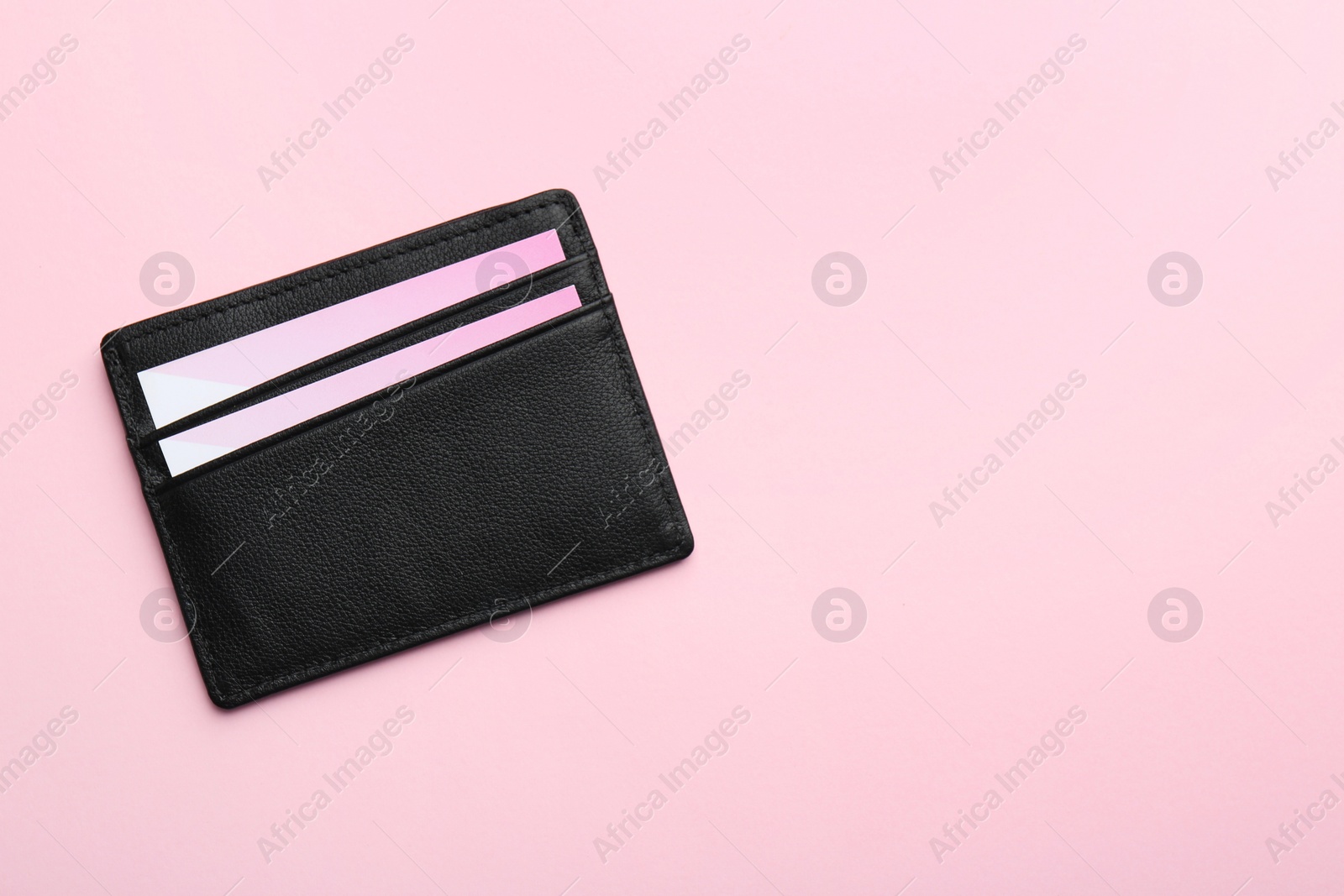 Photo of Leather business card holder with blank cards on pink background, top view. Space for text