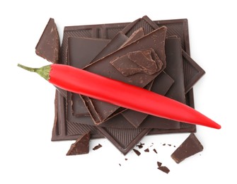Red hot chili pepper and pieces of dark chocolate isolated on white, top view