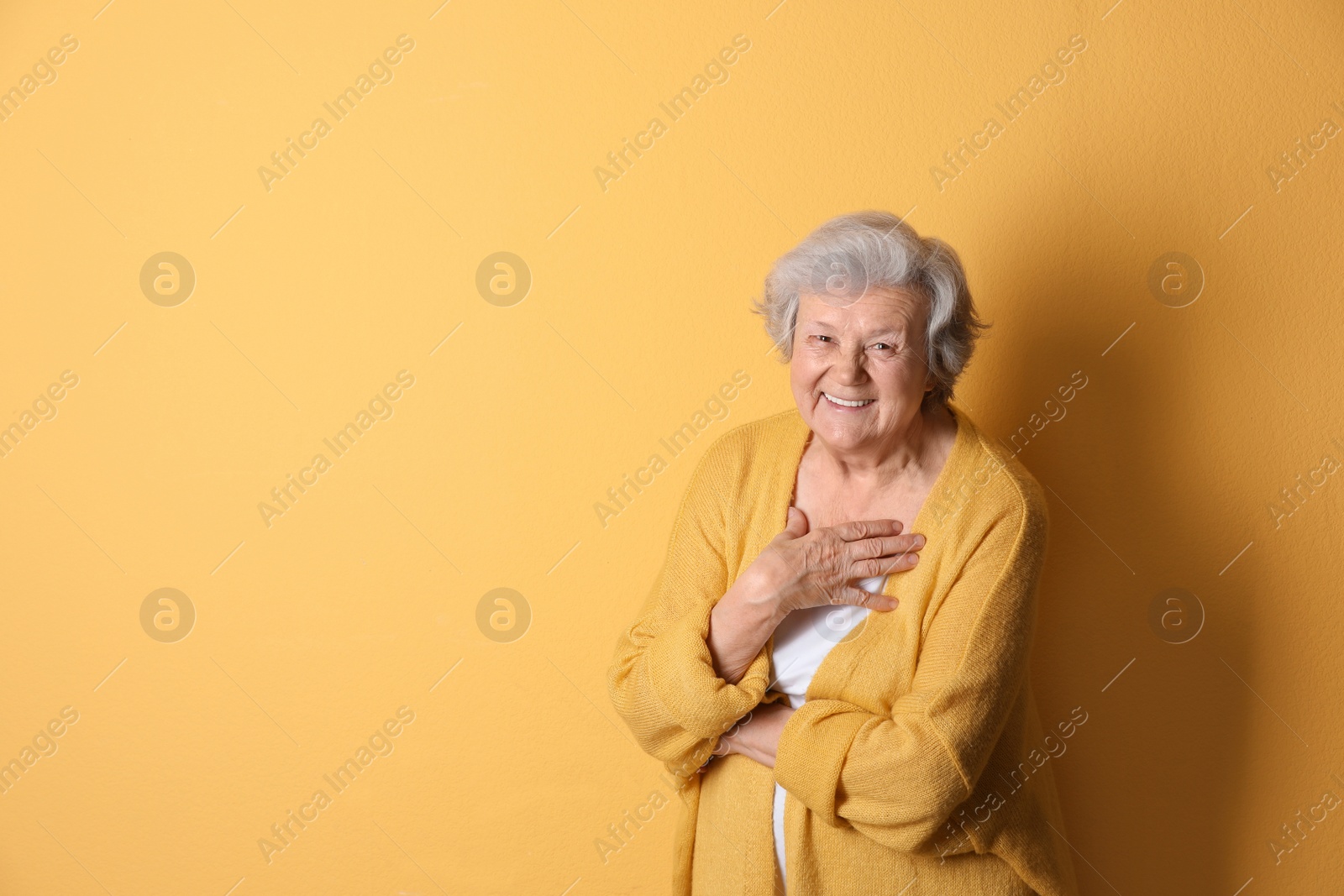 Photo of Portrait of grandmother in stylish clothes on color background, space for text