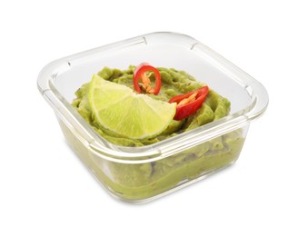 Photo of Bowl of delicious guacamole with chili pepper and lime isolated on white