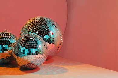 Photo of Bright shiny disco balls on color background, above view. Space for text