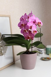 Beautiful pink orchid flower and picture on white table