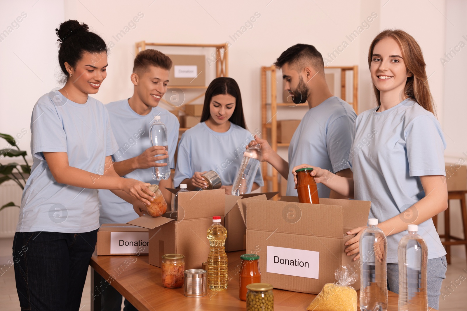 Photo of Group of volunteers packing food products in warehouse