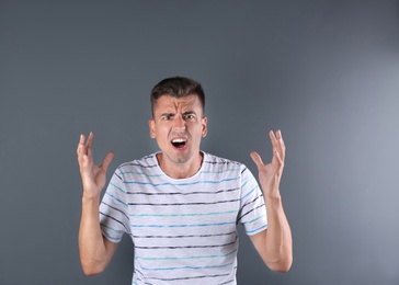 Photo of Handsome emotional young man on color background