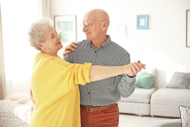 Photo of Elderly couple dancing in living room