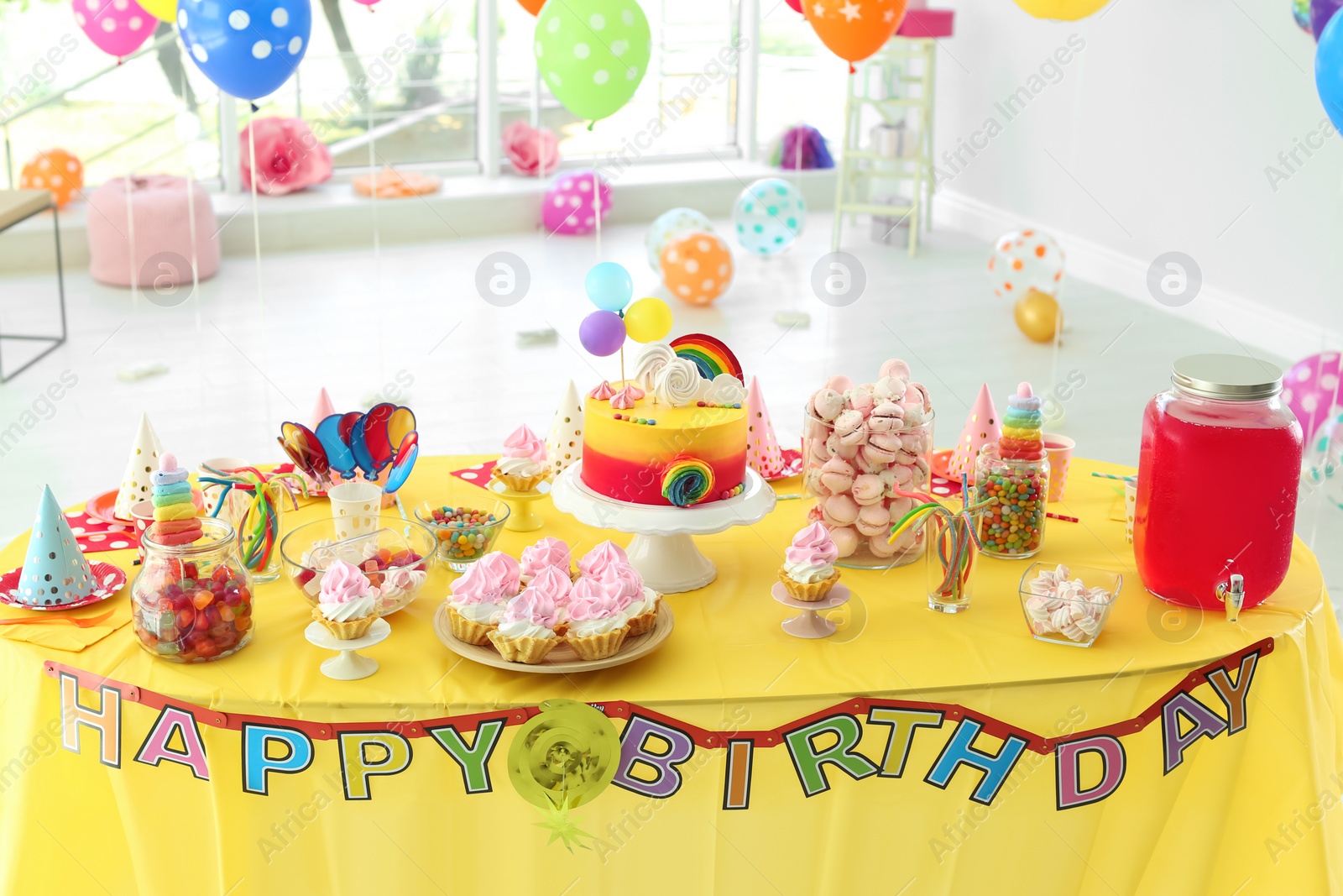 Photo of Table with birthday cake and delicious treats indoors