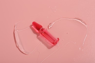Photo of Skincare ampoule on pink surface with gel
