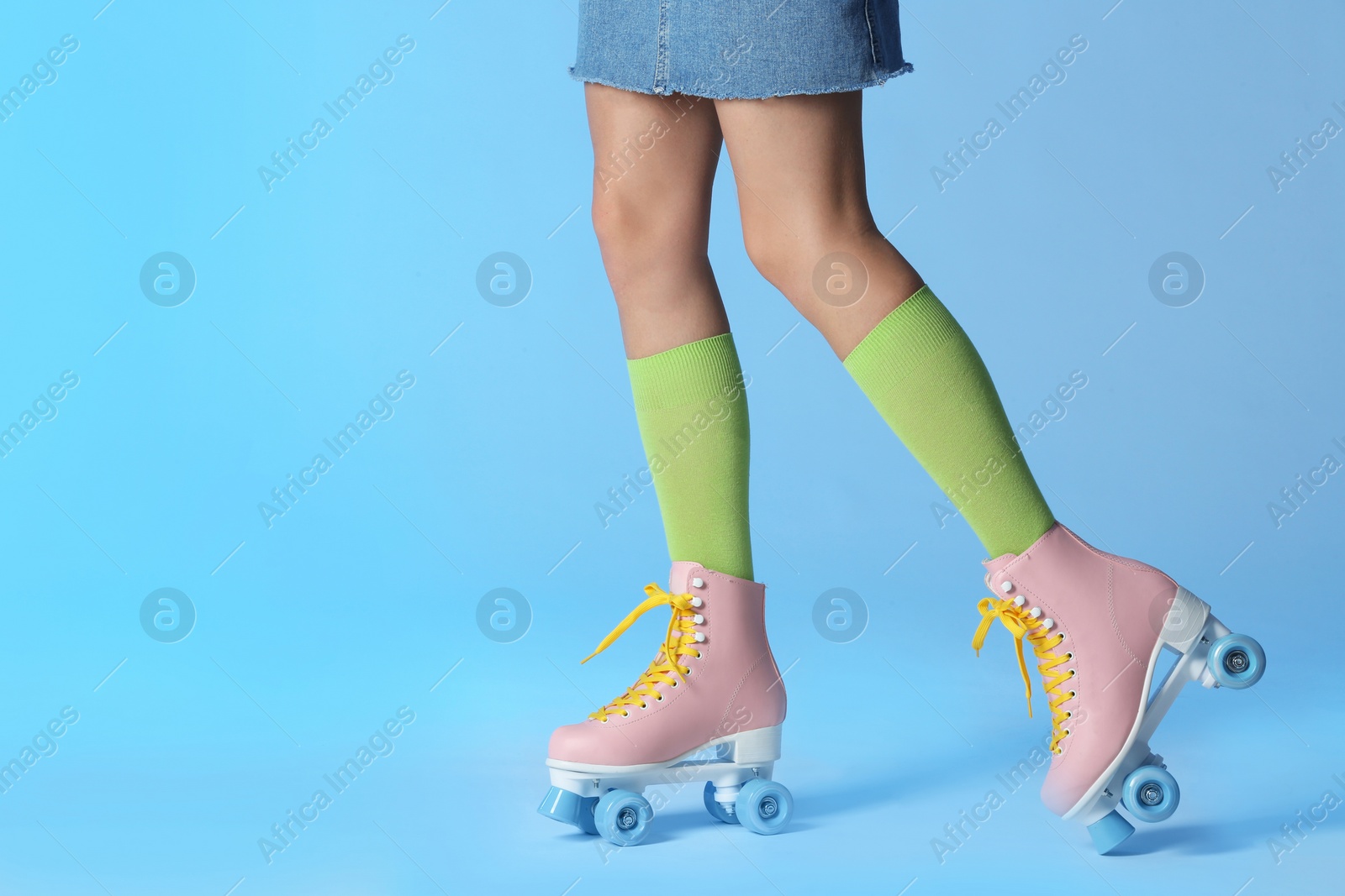 Photo of Woman with vintage roller skates on color background, closeup. Space for text