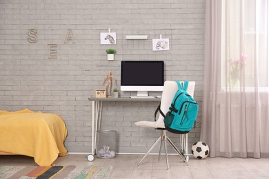 Photo of Comfortable workplace with modern computer in child room