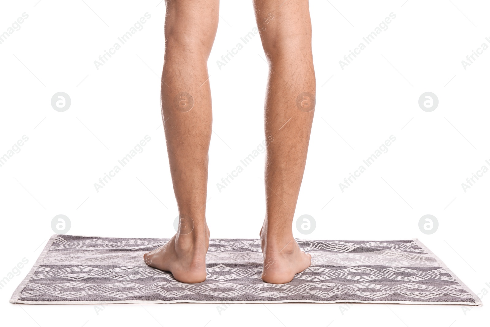 Photo of Man standing on soft bath mat against white background, closeup