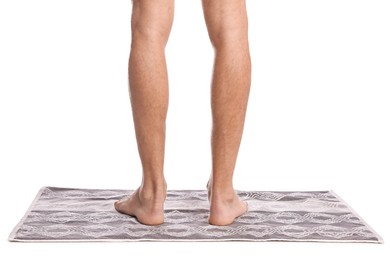 Man standing on soft bath mat against white background, closeup