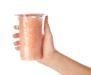 Woman holding plastic cup with yummy cotton candy on white background, closeup