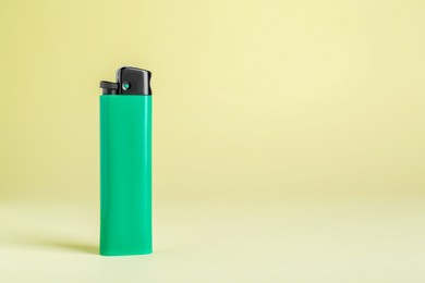 Stylish small pocket lighter on beige background, space for text