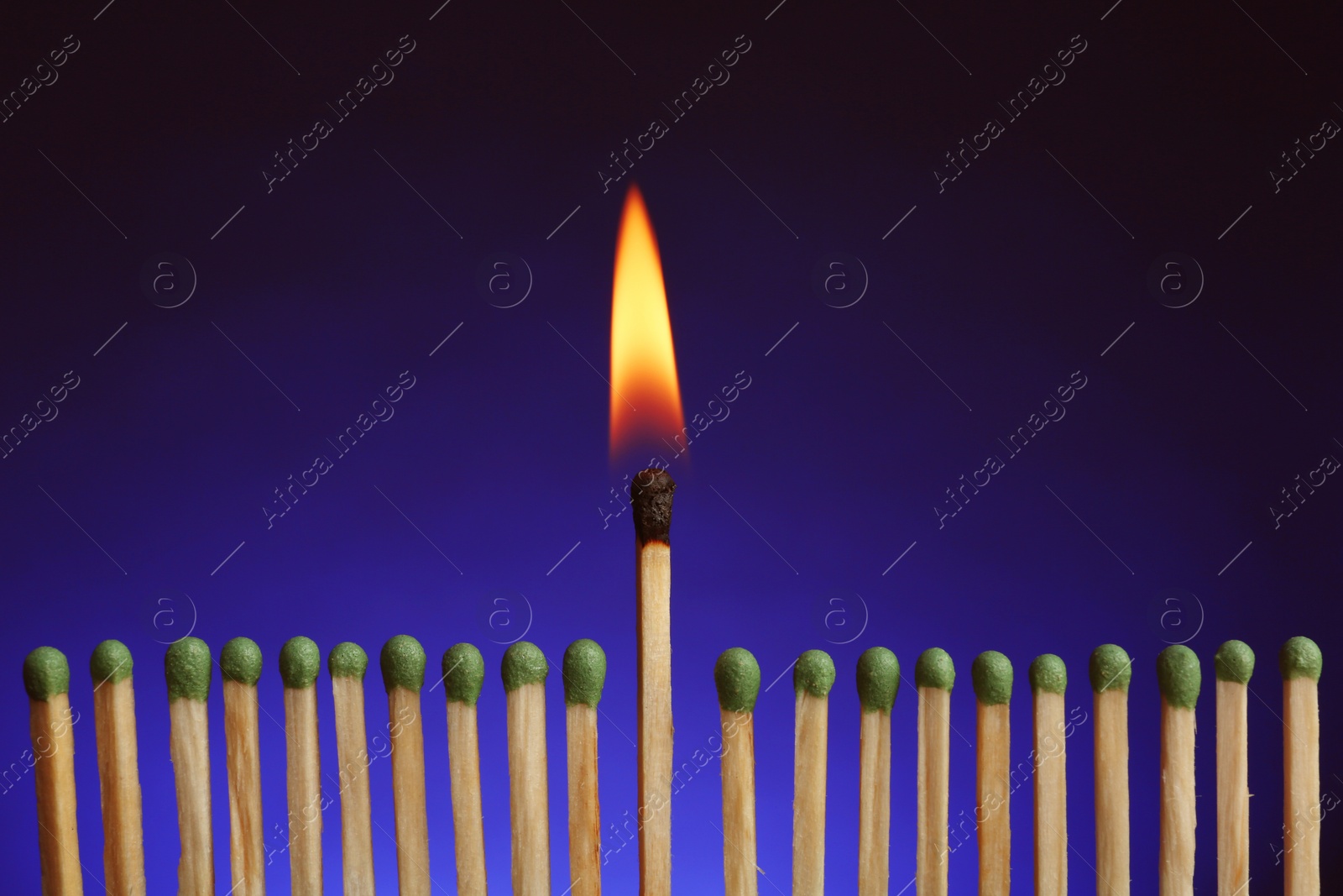 Photo of Burning match among others on color background. Difference and uniqueness concept