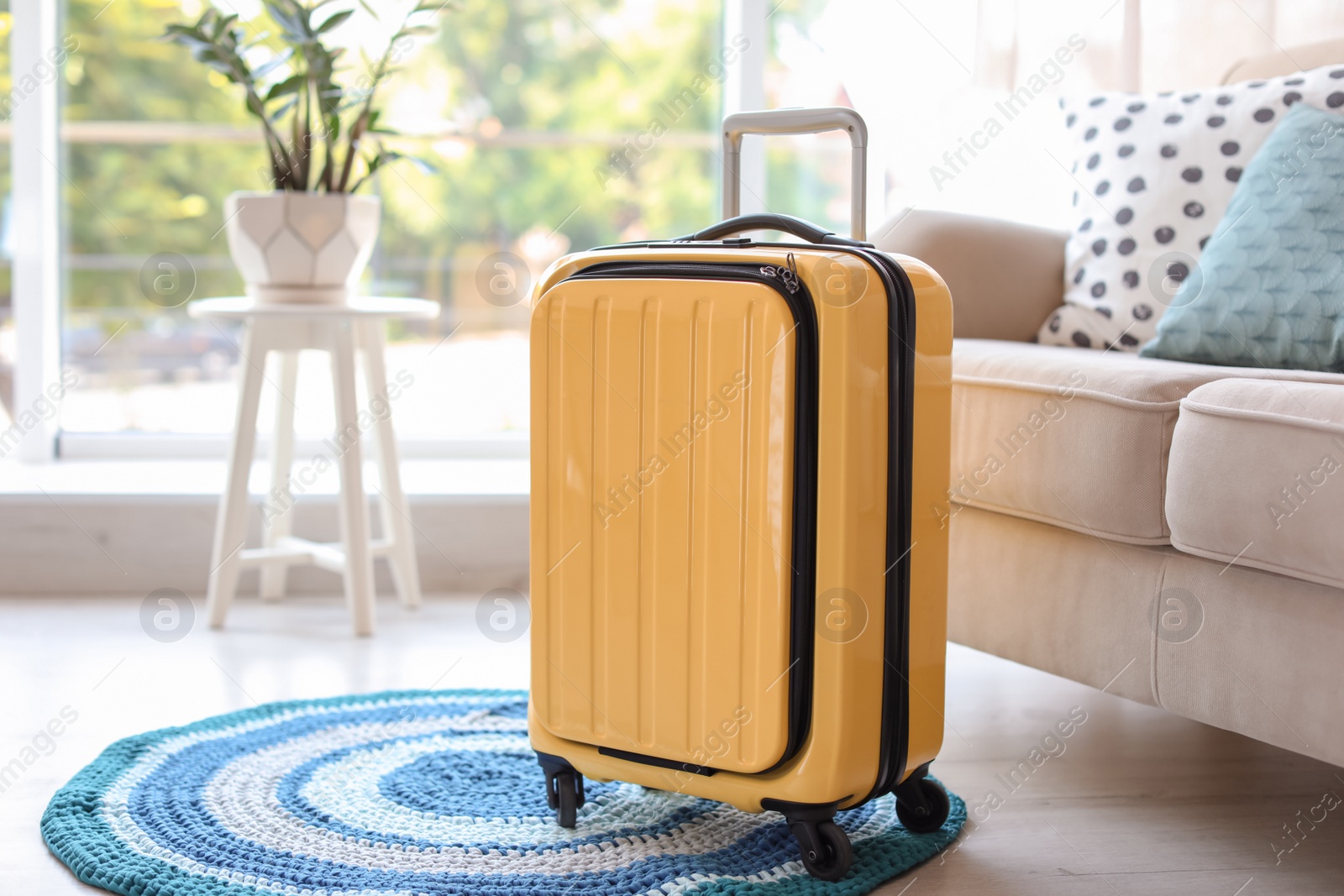 Photo of Bright yellow suitcase packed for journey at home