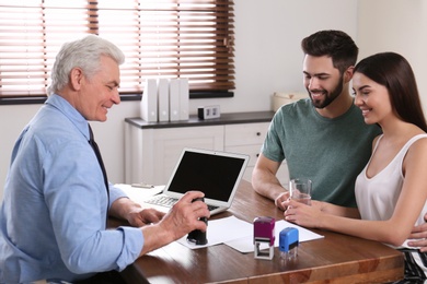 Senior notary working with young couple in office