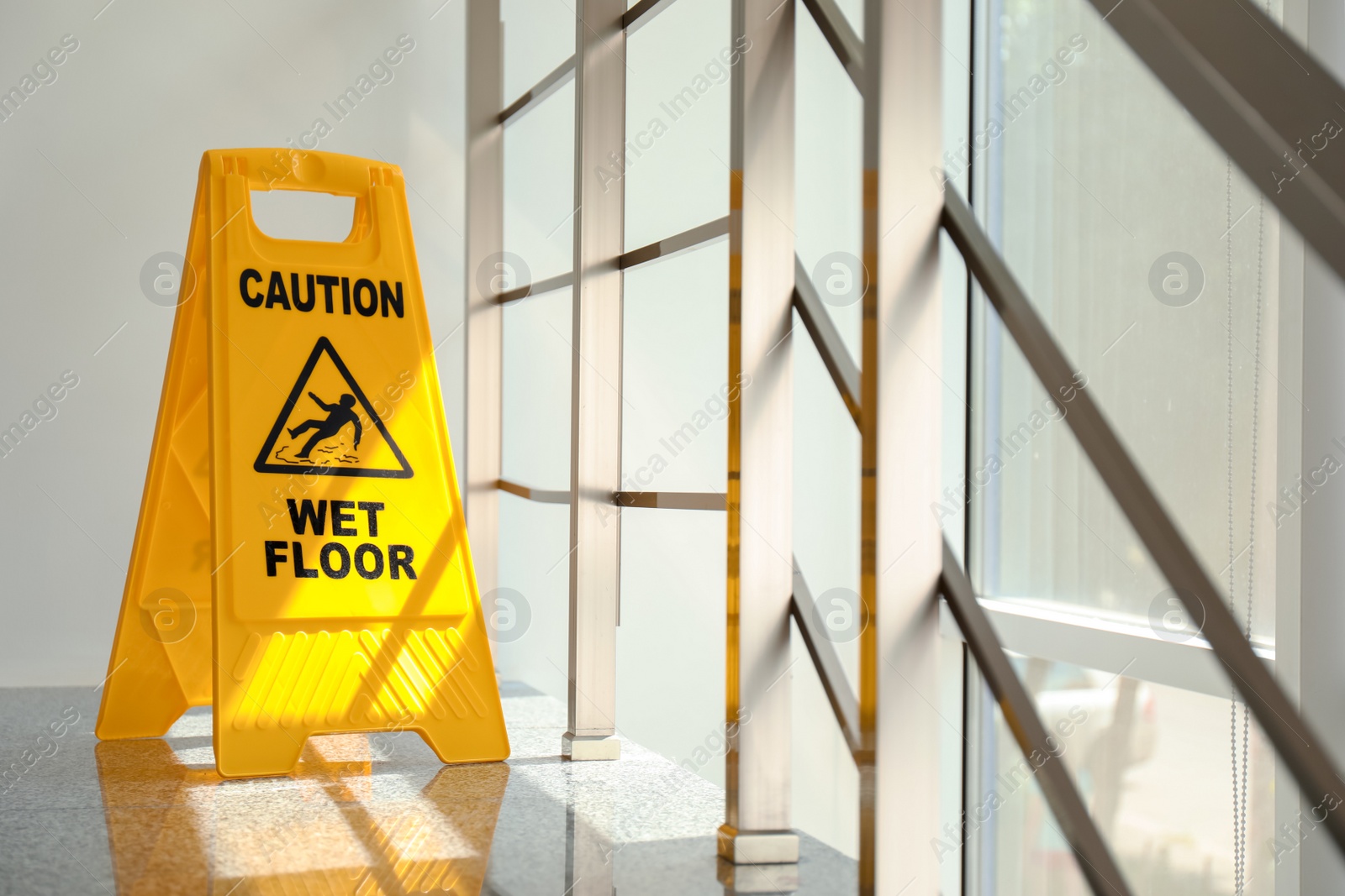 Photo of Safety sign with phrase Caution wet floor, indoors. Cleaning service