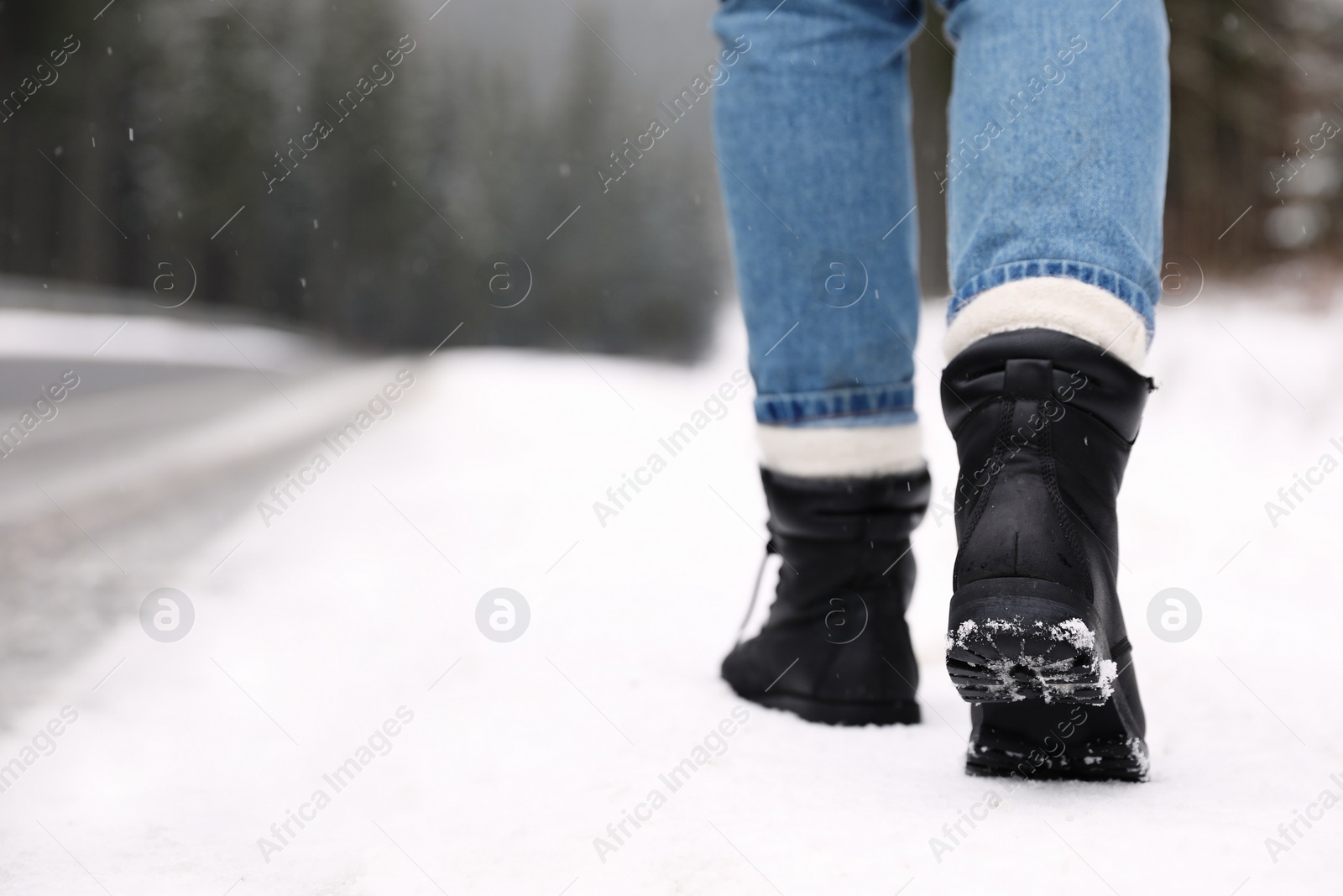 Photo of Woman walking outdoors on snowy winter day. Space for text