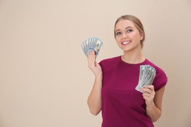 Portrait of happy young woman with money on color background. Space for text