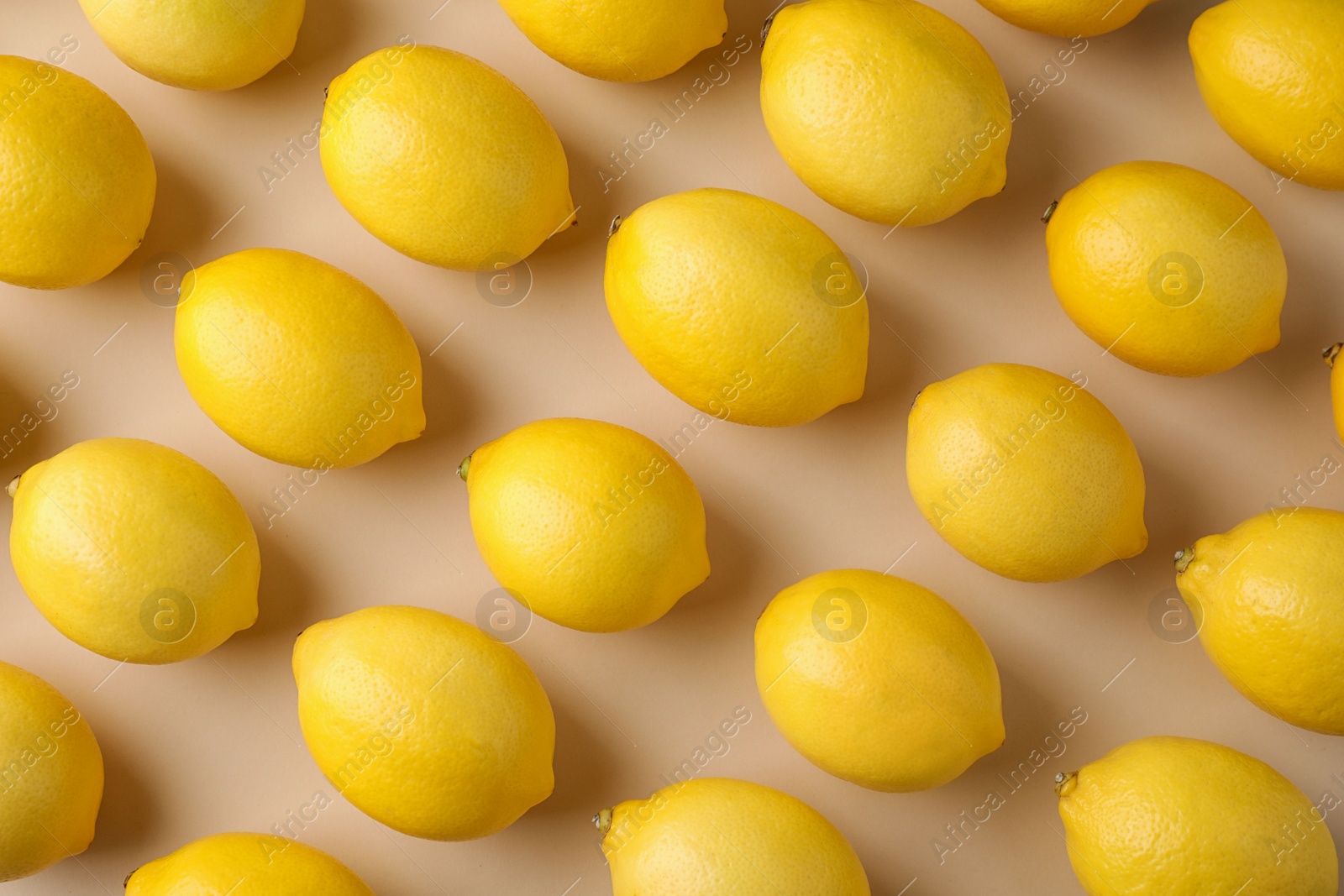 Photo of Ripe fresh lemon fruits on beige background, flat lay