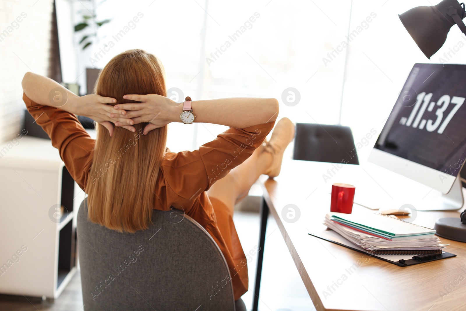Photo of Young woman relaxing at table in office during break