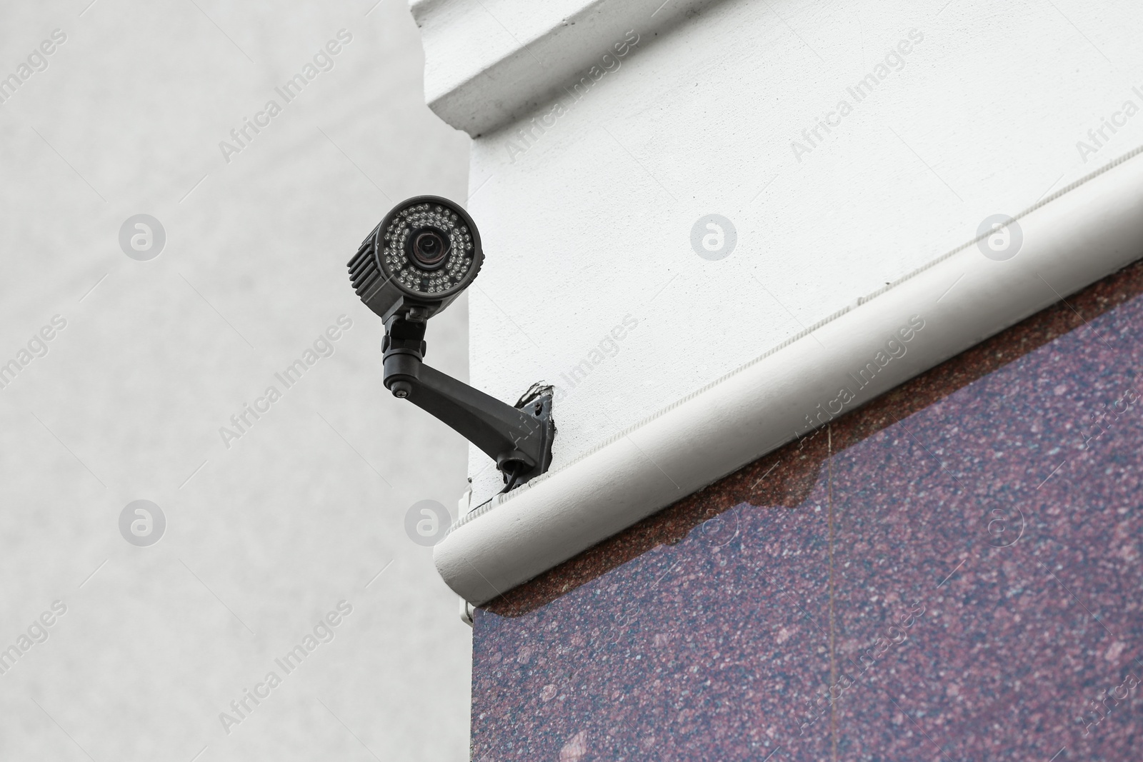 Photo of Modern CCTV security camera on building outdoors. Space for text