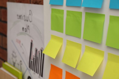 Photo of Blank colorful paper notes on white board, closeup