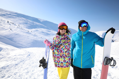 Photo of Couple with snowboards on hill, space for text. Winter vacation