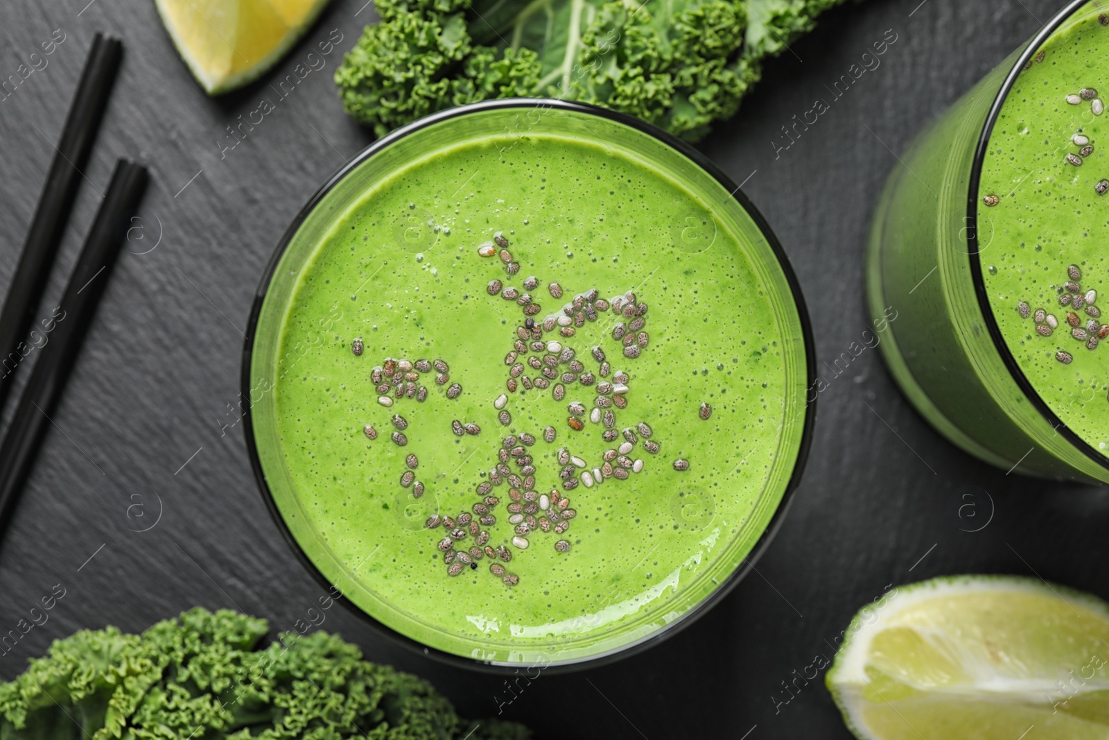 Photo of Tasty kale smoothie on black table, flat lay