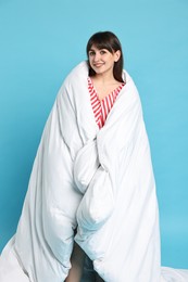 Happy woman with pyjama wrapped in blanket