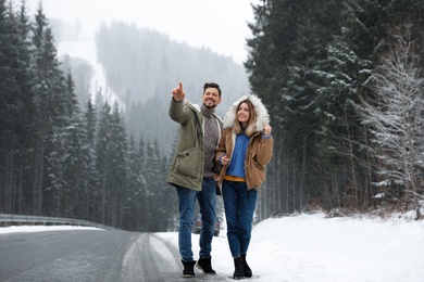 Photo of Couple walking near snowy forest. Winter vacation