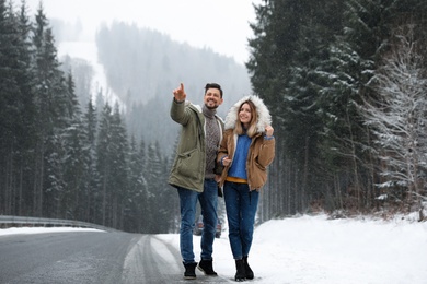 Couple walking near snowy forest. Winter vacation