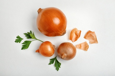 Flat lay composition with ripe onions on light background