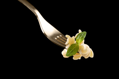 Photo of Fork with delicious fusilli pasta on black background