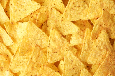 Photo of Tasty Mexican nachos chips as background, top view