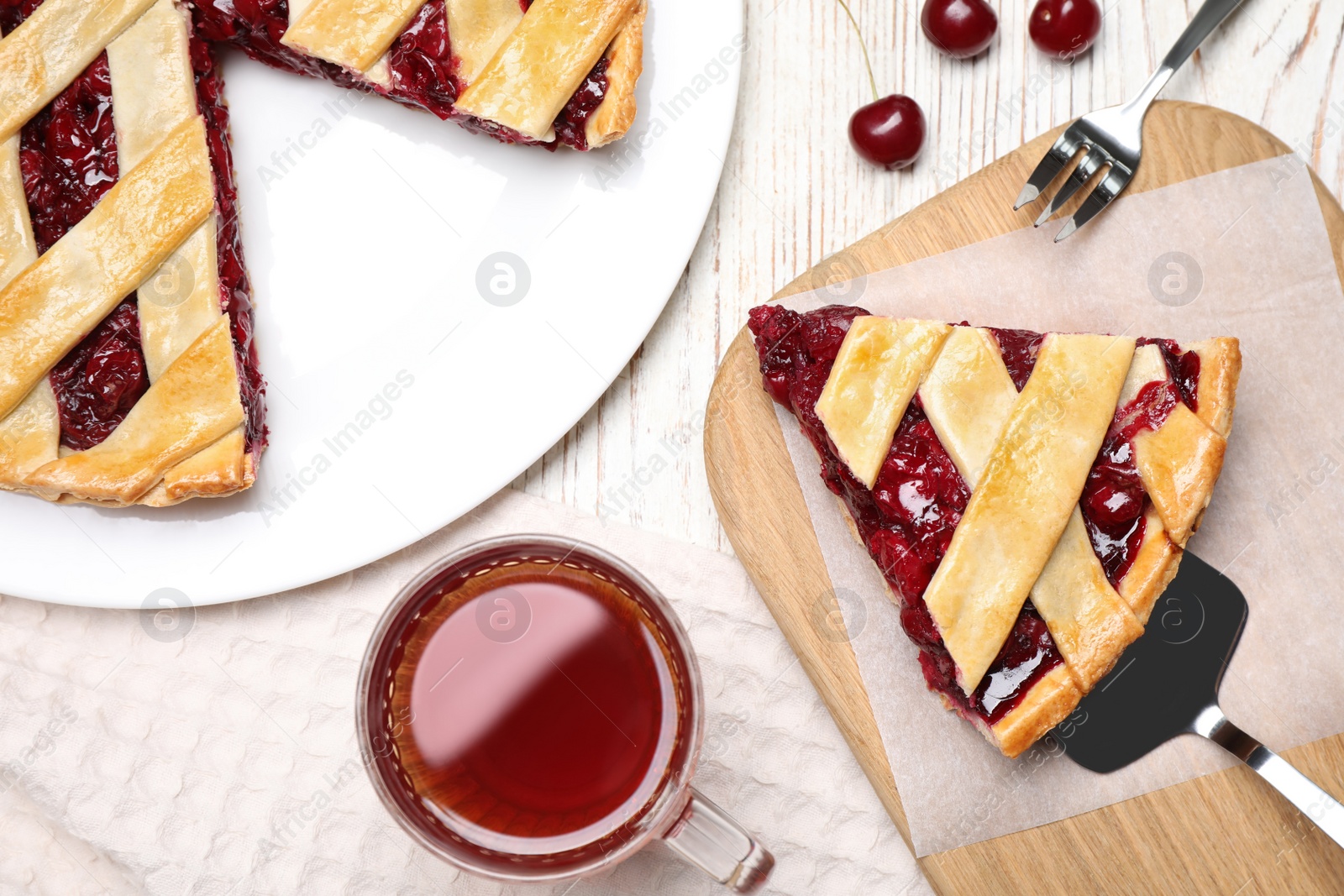 Photo of Delicious fresh cherry pie served on white wooden table, flat lay